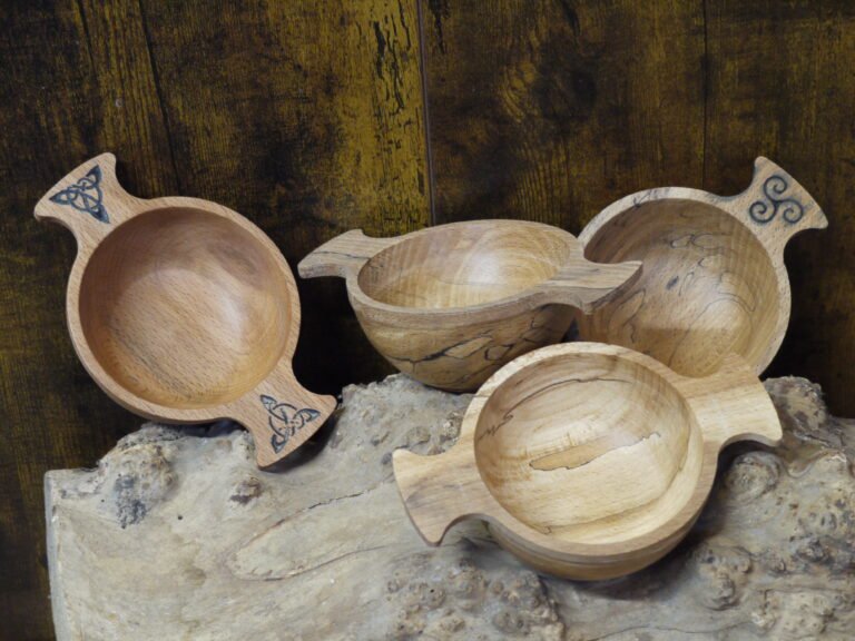 Quaichs displayed on a log